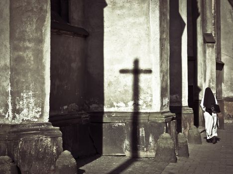 Dark and mystical atmosphere with a nun entering in a church
