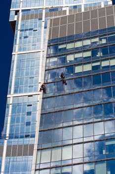Two men cleaning windows of a skyscraper