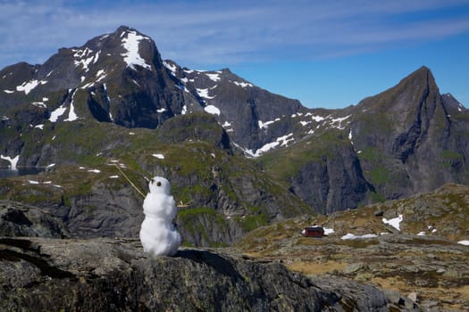 Snowman in far north on Lofoten Islands in Norway during short arctic summer