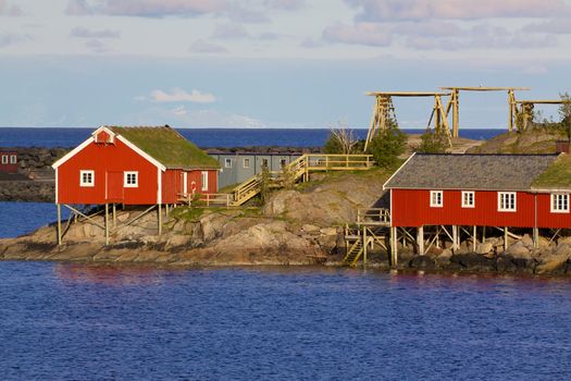 Typical red rorbu huts with sod roof in town of Reine on Lofoten islands in Norway