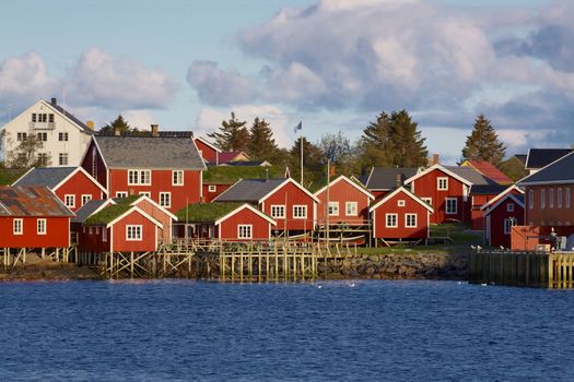 Typical red rorbu huts with sod roof in town of Reine on Lofoten islands in Norway