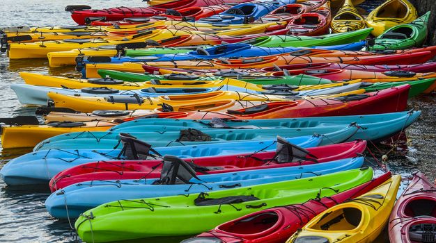 Colorful fiberglass kayaks tethered to each other