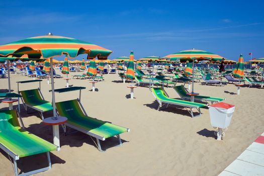 chaise longue and umbrellas on a sandy beach in Rimini, Italy