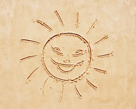 Smiling sun. Drawing of the child on sand