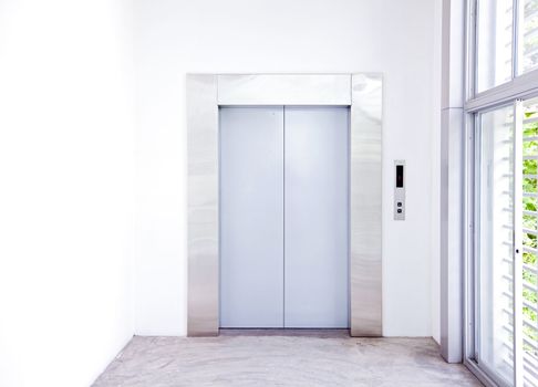 Front view of a modern elevator with closed doors in lobby