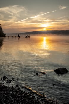 An old jetty with peolpe doing early sport