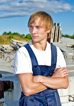 Handsome builder in coveralls on construction site