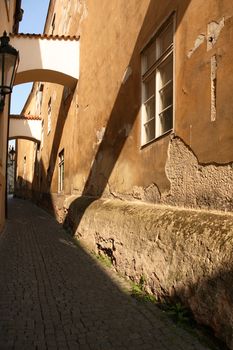 Narrow street in old town with sunbeam at dawn