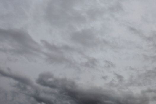 Black clouds against gray rainy winter sky. Nature background.
