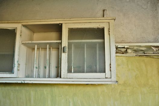 Dusty vintage cupboard and textured wall in abandoned house interior.