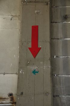 Concrete factory wall and arrow signs. Industrial background.