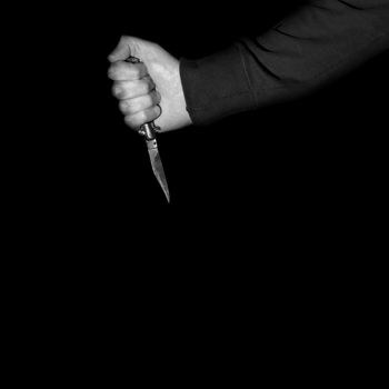 Killer holding vintage folding knive stiletto switchblade. Violent crime social issues.