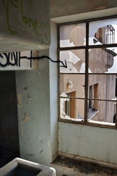 Shattered window with painted arrow. Abandoned house interior.