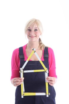 Woman holding a ruler folded in the form of a house with a lovely smile as she dreams and plans for her new home 