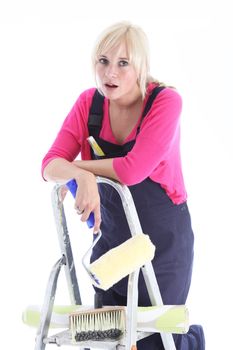 Tired woman flopped over the top of the ladder taking a break from doing wallpapering and redecorating in her home 