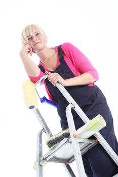 Attractive female painter posing on ladders isolated on white 