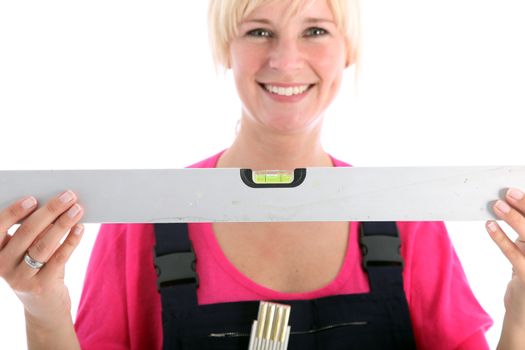 Smiling female worker holding a spirit level isolated on white Smiling female worker holding a spirit level isolated on white