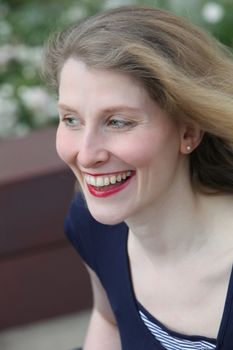 Closeup portrait of a friendly smiling attractive middle-aged woman glancing to her right away from the camera