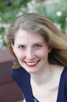 Attractive middle-aged woman with a wide friendly smile looking up at the camera 