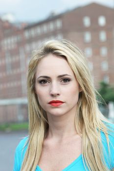 Beautiful woman with strong features and a steady gaze indicative of a determined personality in an urban environment Beautiful woman with strong features and a steady gaze indicative of a dtermined steadfast personality in an urban environment