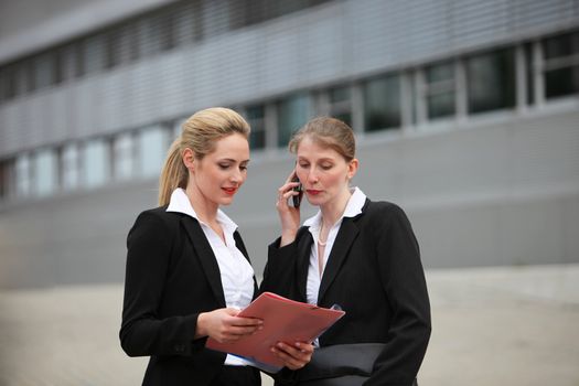 Two business women in front of business building Two business women in front of business building