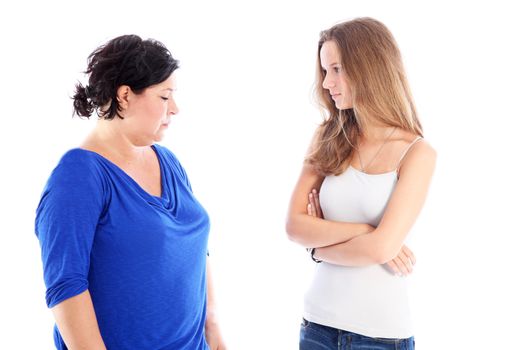 Mother and her teenage daughter standing facing each other in a stand off during a disagreement isolated on white Mother and her teenage daughter standing facing each other in a stand off during a disagreement isolated on white