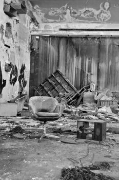 Dusty chair in abandoned vinyl records pressing factory. Black and white.