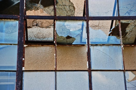 Smashed glass and rusty metal background. Vandalized attrium of derelict building.
