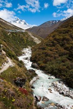 Himalaya landscape: peak, river and highland village. Pictured in Nepal