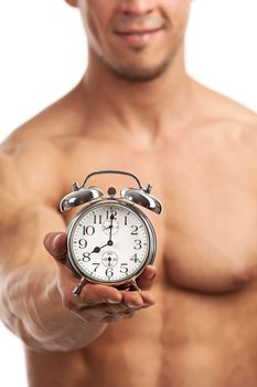 Cropped view of a muscular young man holding clock over white background, It is high time for workout concept.