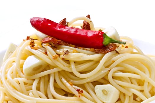 pasta garlic olive oil and red chili pepper closeup on a white dish