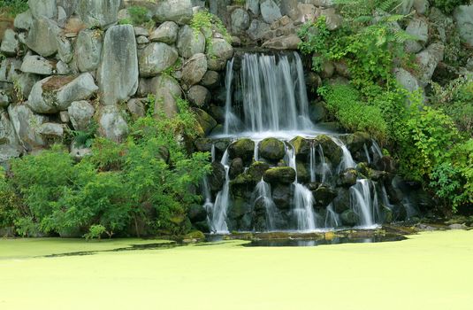 A waterfall on a algae covered pond