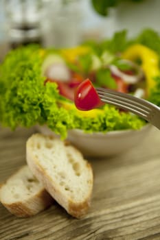 fresh tasty healthy mixed salad and bread on wooden table