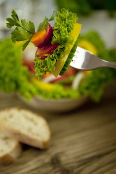 fresh tasty healthy mixed salad and bread on wooden table