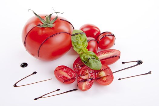 fresh red tomatoes with balsamic and oilve oil isolated on white background