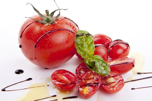 fresh red tomatoes with balsamic and oilve oil isolated on white background