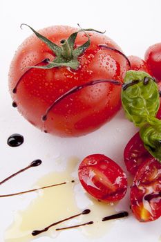 fresh red tomatoes with balsamic and oilve oil isolated on white background