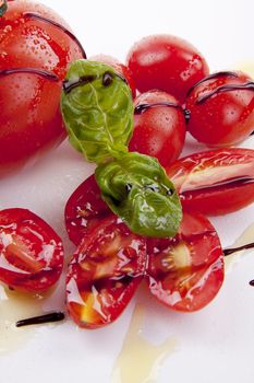 fresh red tomatoes with balsamic and oilve oil isolated on white background