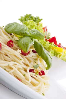 fresh pasta with chilli and basil with salad isolated on white background
