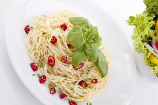 fresh pasta with chilli and basil with salad isolated on white background