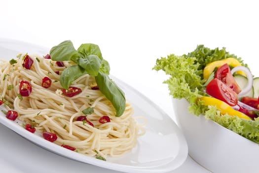 fresh pasta with chilli and basil with salad isolated on white background