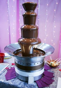 Melted chocolate (chocolate fondue) dripping down a fountain structure