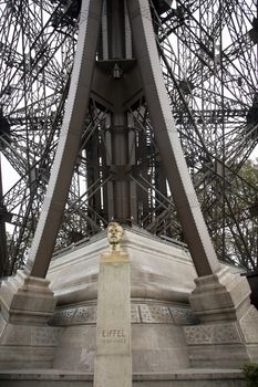 Bust of Gustave Eiffel the creator of the famous Eiffel Tower in Paris, France in front of the tower itself.