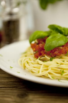 delicious fresh spaghetti with tomato sauce and parmesan on wooden table