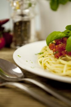 delicious fresh spaghetti with tomato sauce and parmesan on wooden table