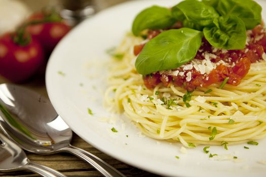 delicious fresh spaghetti with tomato sauce and parmesan on wooden table