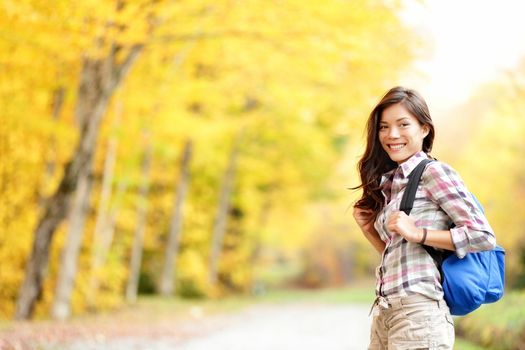 Fall hiking girl. Woman hiker portrait in forest in autumn colors. Beautiful young mixed race female on hike. Image from Mont Sutton, Quebec, Canada.