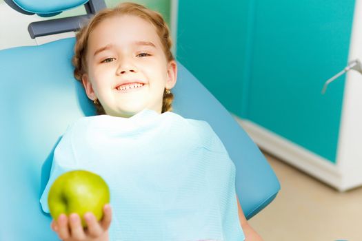 Little girl sitting in the dentists office