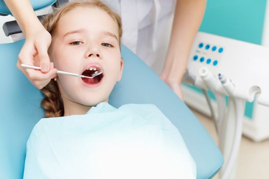 Little girl sitting in the dentists office