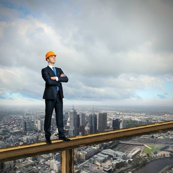 Business man standing high over a cityscape